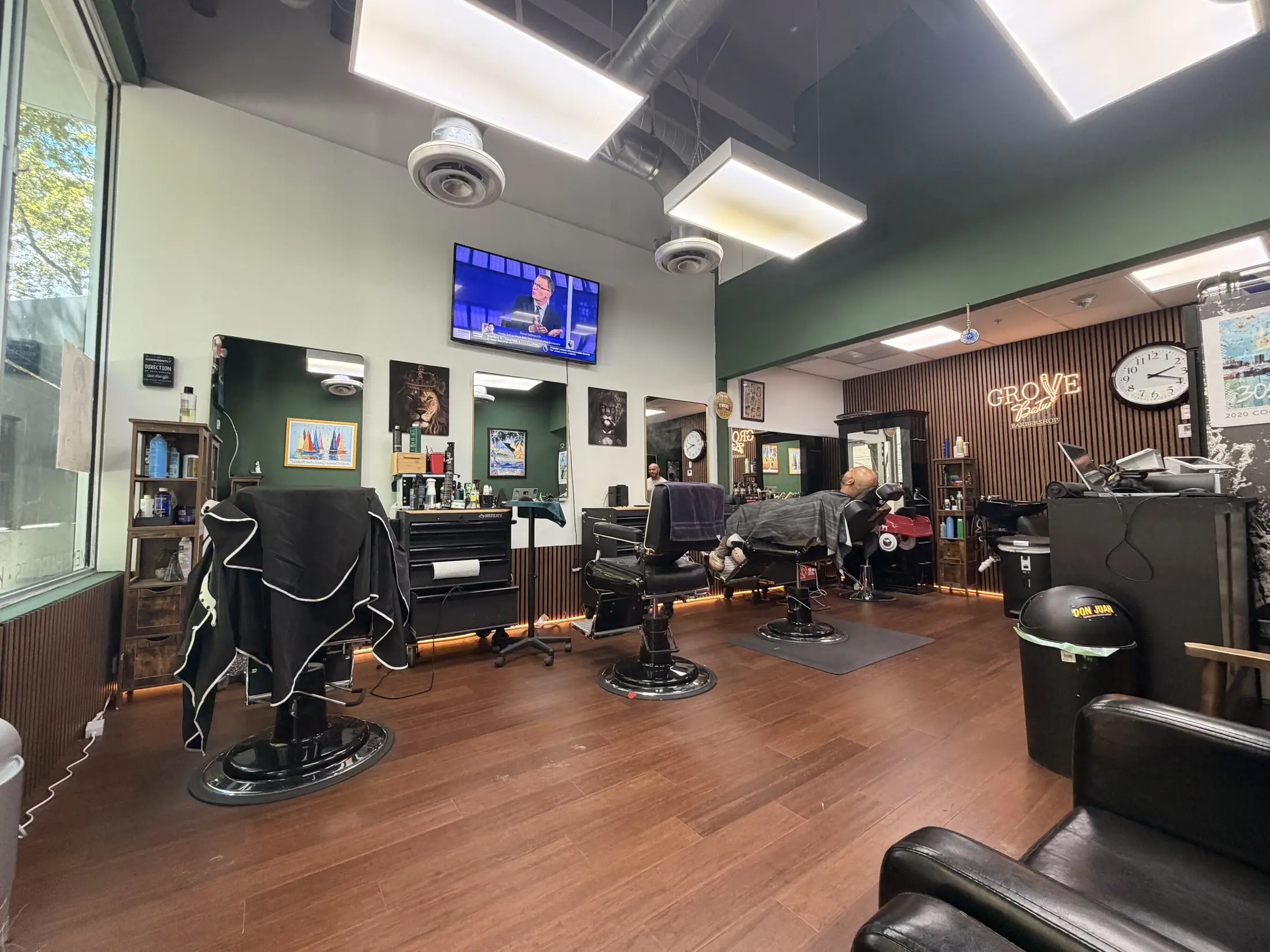 The renovated interior of Grove Batu Barbershop in Coconut Grove, with three barber chairs and wood floors